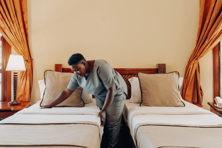 A Salinero team member preparing a guest room in Moshi